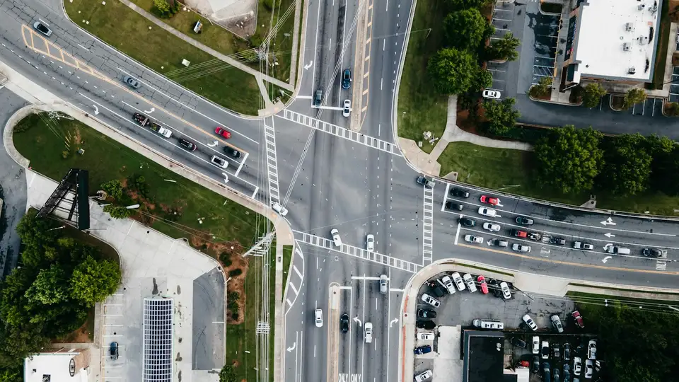 Vista aérea de una intersección con cruces peatonales y autos detenidos en varias filas